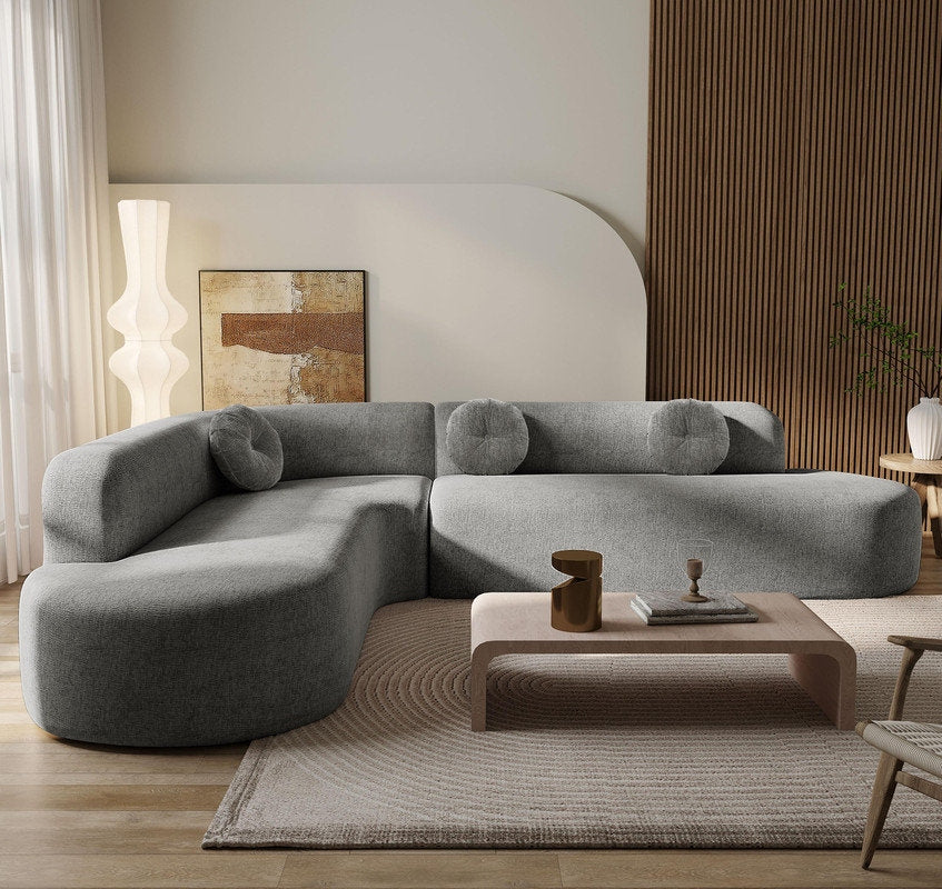Gray sectional sofa in a modern living room with a coffee table and decorative items.
