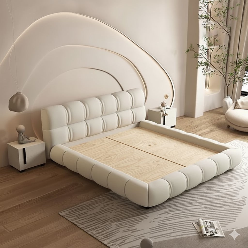 Modern bedroom with a large white bed and decorative elements.
