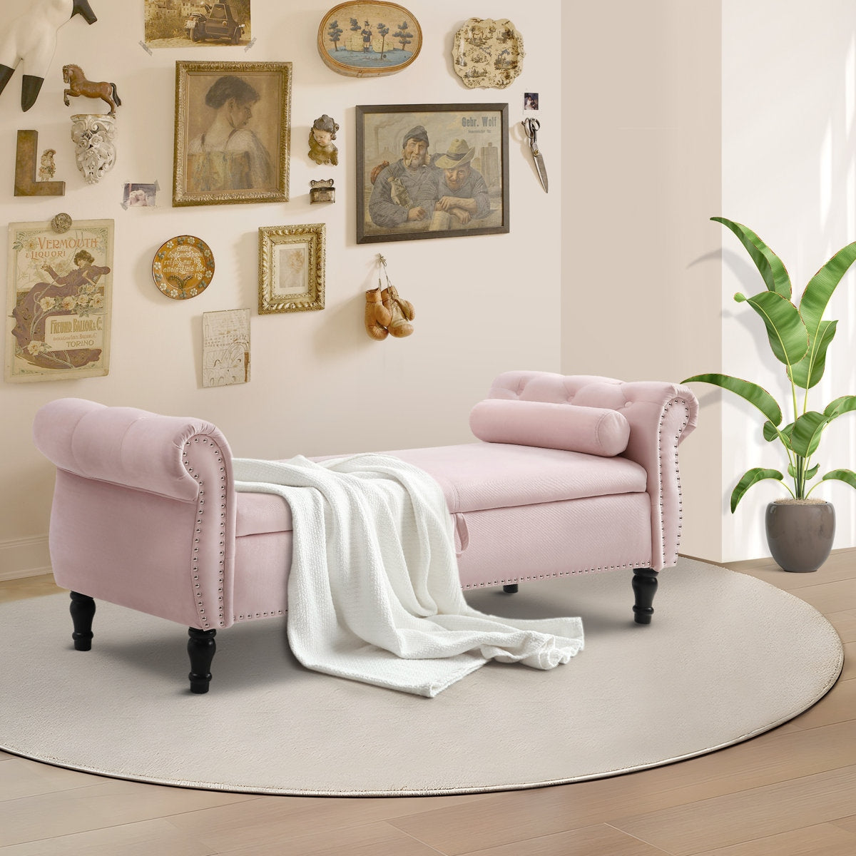 Pink upholstered bench with a white blanket in a room with decorative wall art and a plant.