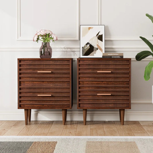 Two mid-century modern wooden bedside tables with two drawers each, placed on either side of a wall unit, with decorative items on top.