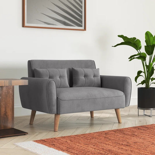 Gray sofa in a room with a plant and wooden table