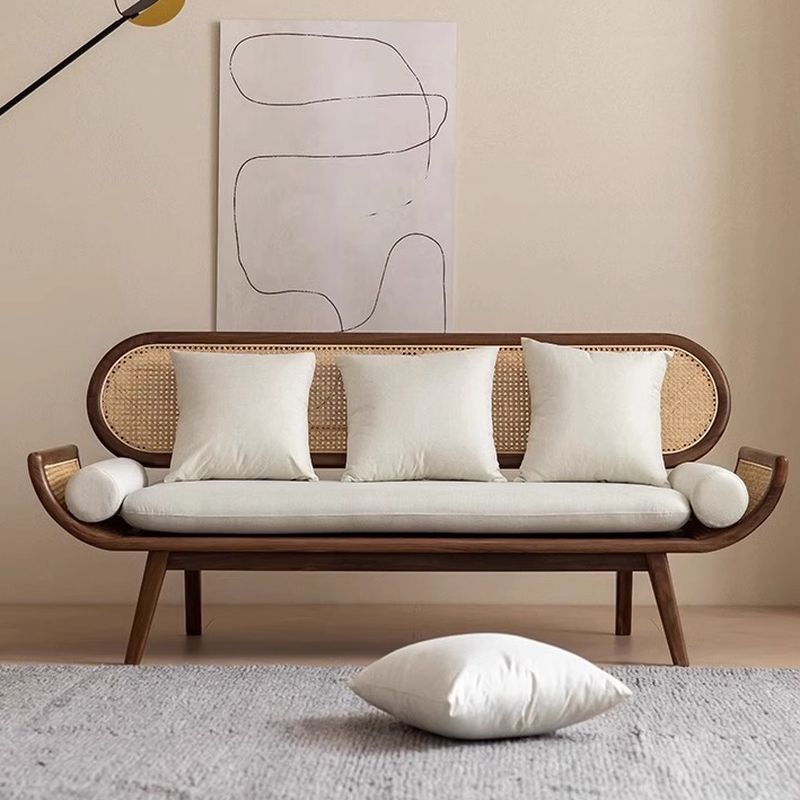Modern sofa with wicker backrest and wooden frame in a minimalistic room.
