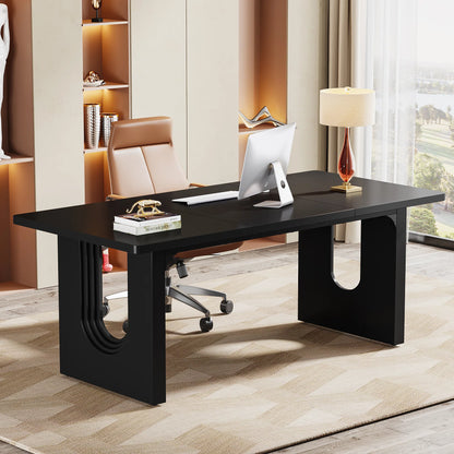 A sleek black executive desk with sculpted panel legs in an office setting, with an office chair and lamp in the background.