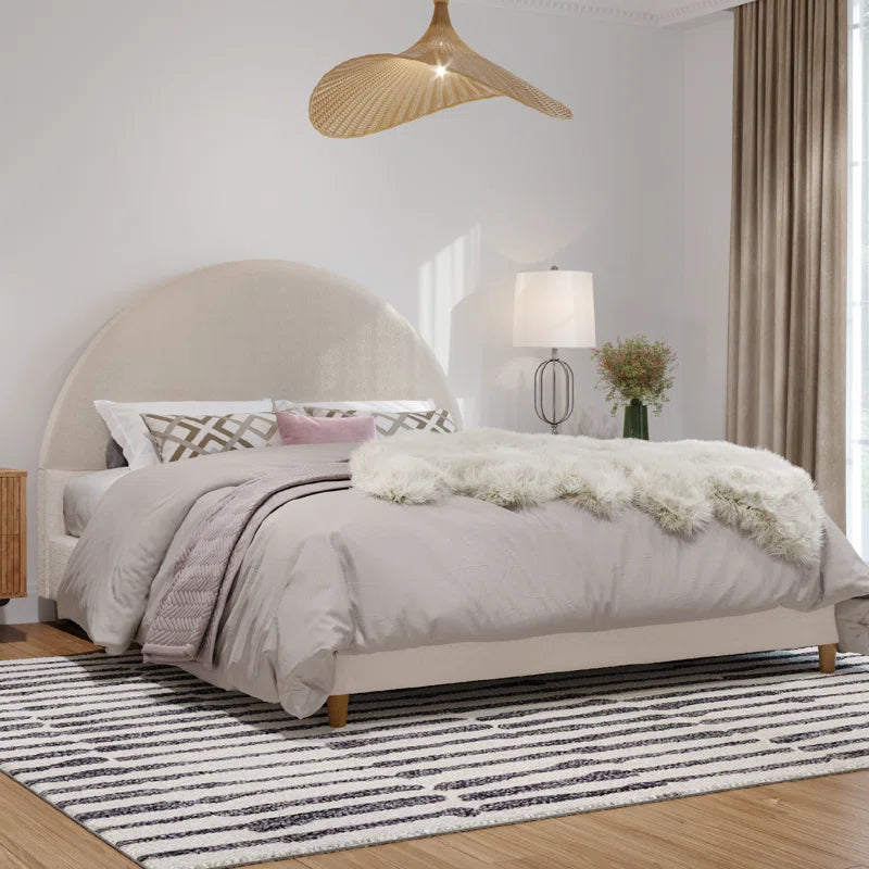 Neatly made bed with gray bedding in a bedroom setting.