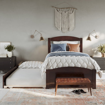 Bedroom with wooden bed, pillows, and a wall hanging.