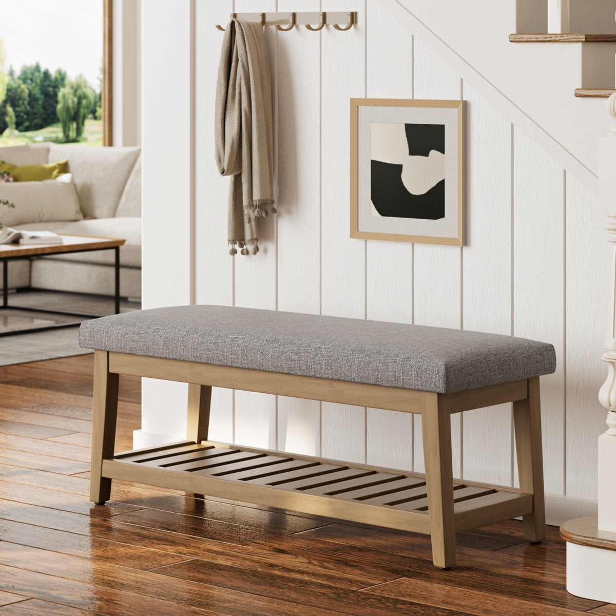 Gray upholstered bench with wooden frame in a living room setting
