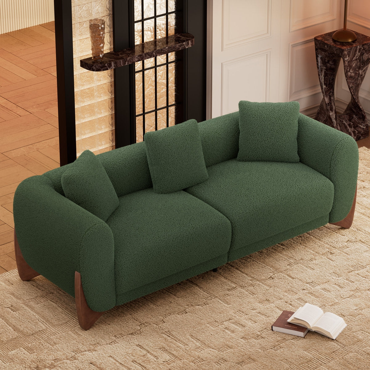 Green sofa in a room with a book and open magazine on the floor.