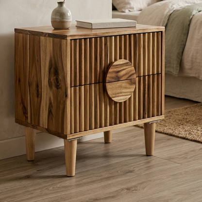 Wooden nightstand with a round drawer in a bedroom setting