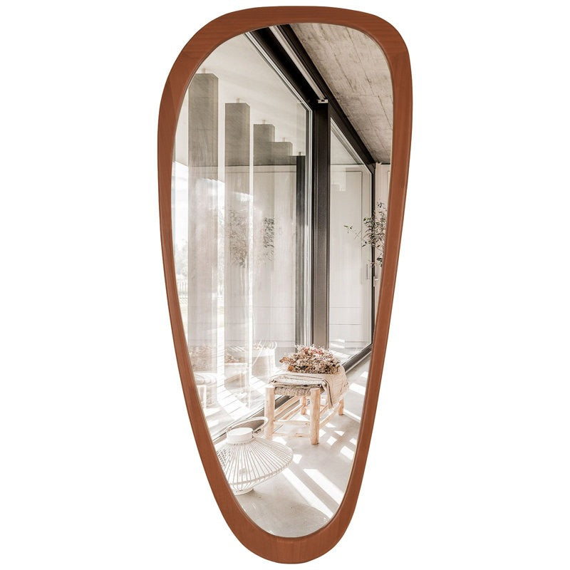 Wooden-framed mirror reflecting a room with furniture and decor.