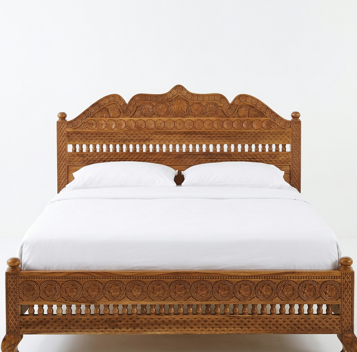 Wooden bed with intricate carvings on a white background