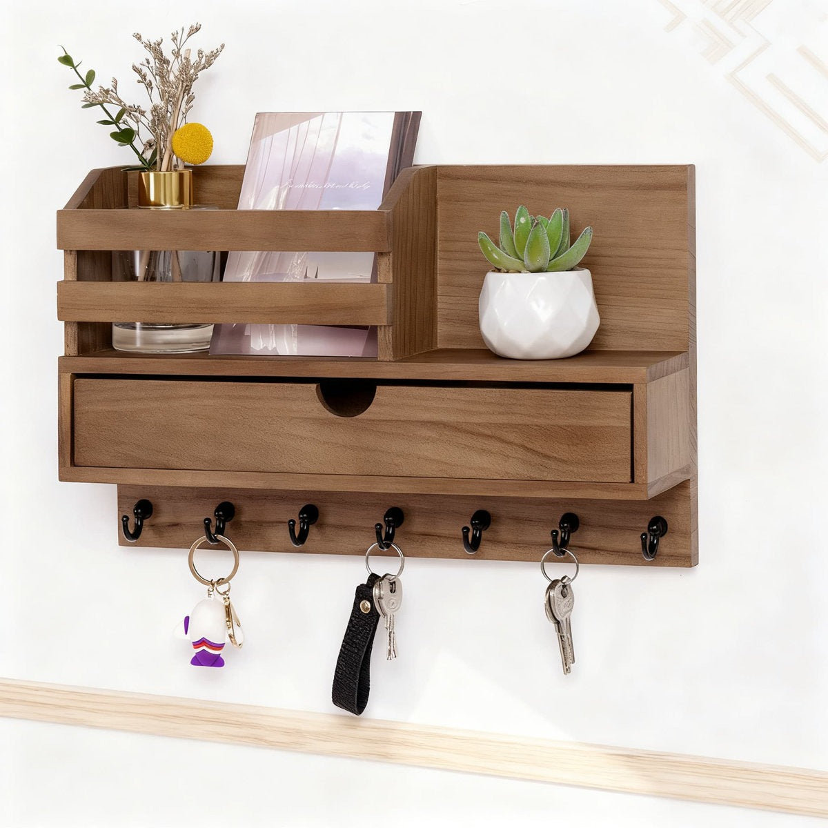 Wooden wall shelf with a drawer and hooks, decorated with plants and items.