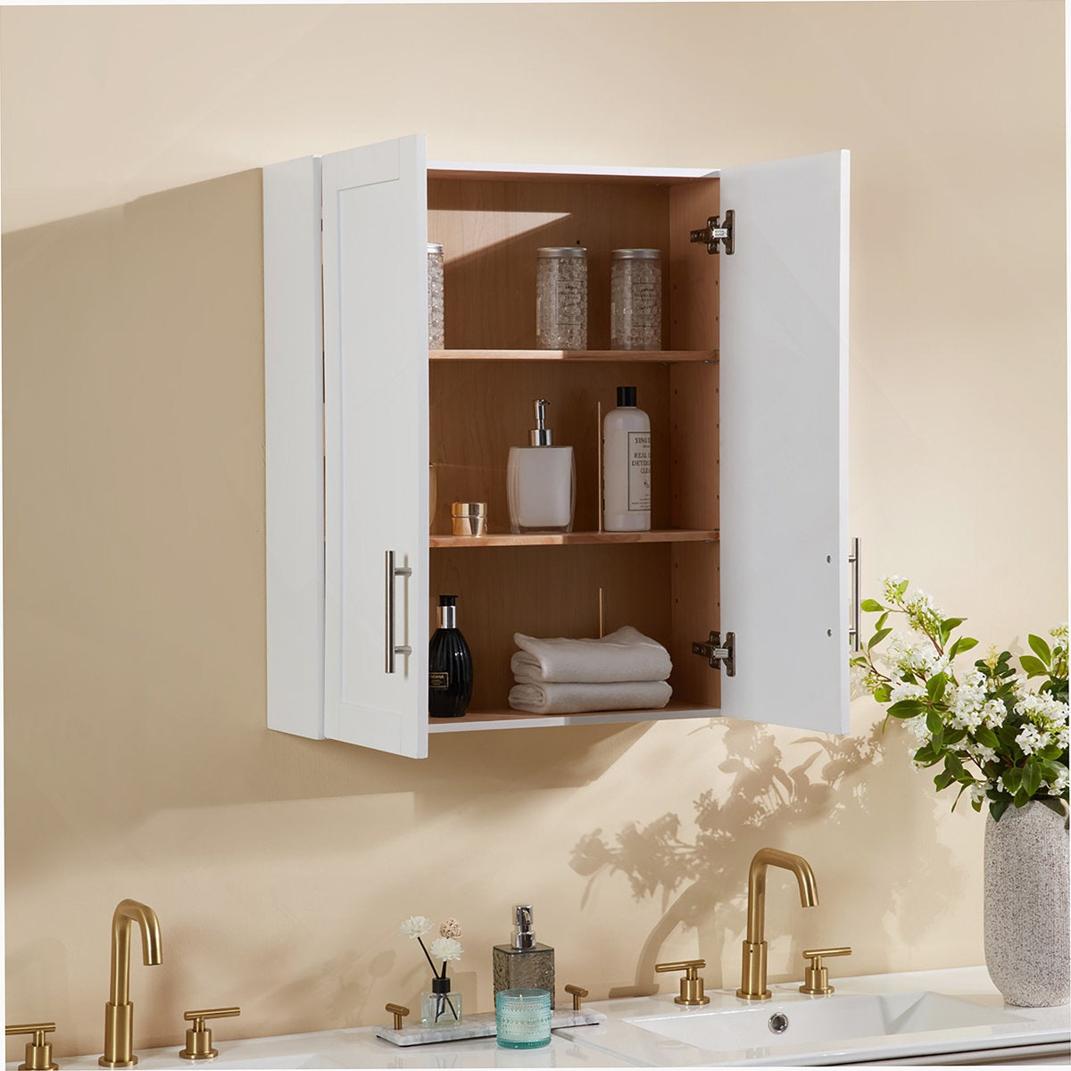 Bathroom cabinet with open doors displaying toiletries, next to a sink with gold fixtures.