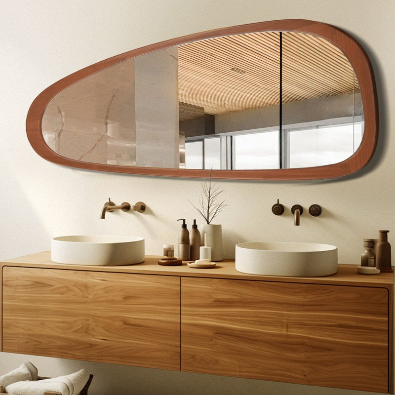 Bathroom vanity with wooden cabinets, round mirror, and white sinks.