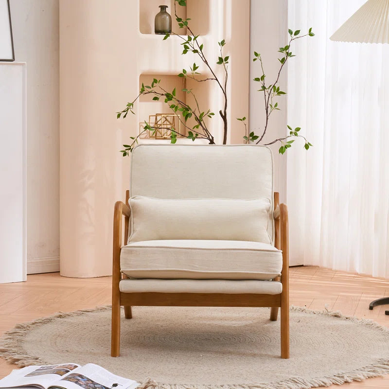 Beige armchair in a room with a plant and open book on a rug