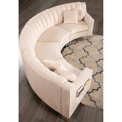 Beige curved sectional sofa on a wooden floor with a patterned rug.