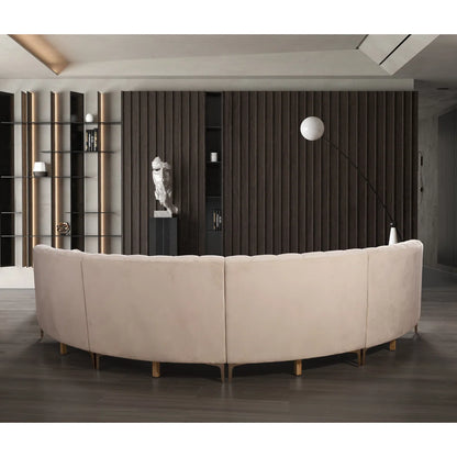 Beige curved sofa in a modern room with dark wood paneling and shelves.