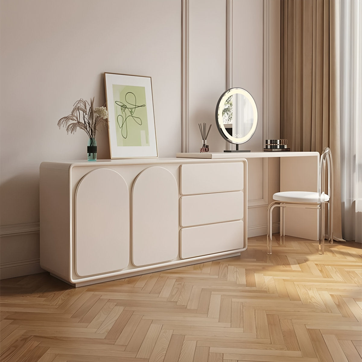 Beige dresser with round mirror and chair in a room with framed artwork and plants.