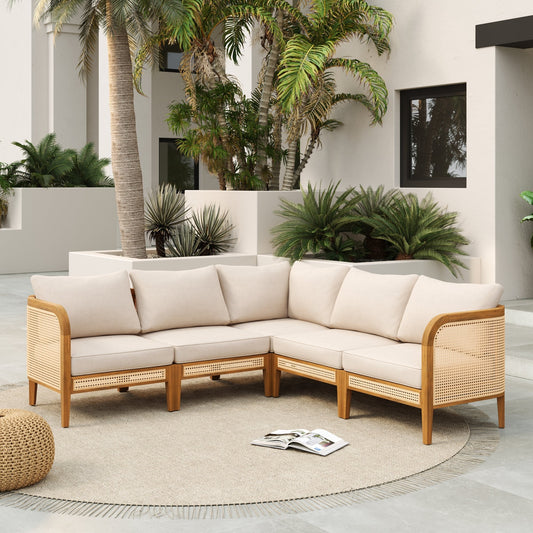 Beige outdoor sectional sofa with wicker frame in a patio setting with plants and a magazine.