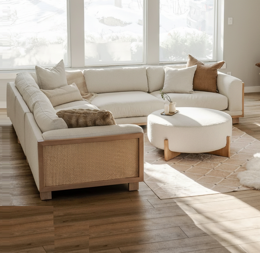 Beige sectional sofa with wooden accents in a bright living room.
