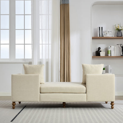 Beige sofa in a living room with a window and bookshelf in the background