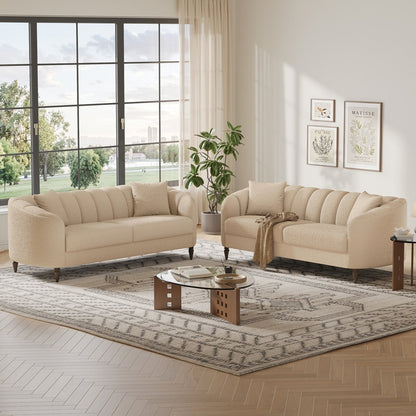 Beige sofa set in a living room with large windows and decorative elements.