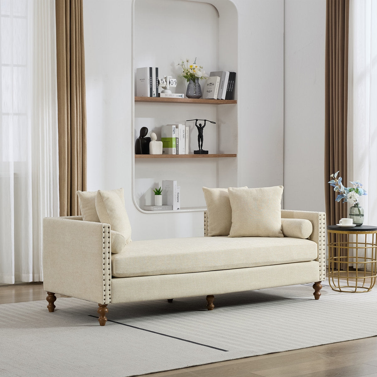 Beige sofa in a living room with a shelf and decor items.