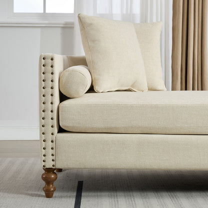 Beige sofa with decorative pillows in a room with white walls and curtains.