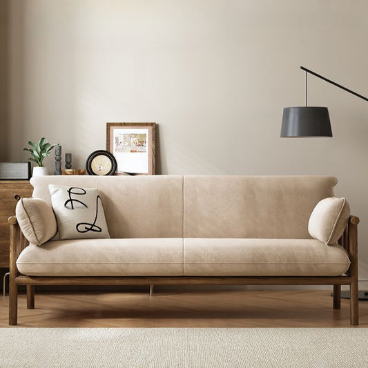 Beige sofa with decorative pillows in a living room setting.