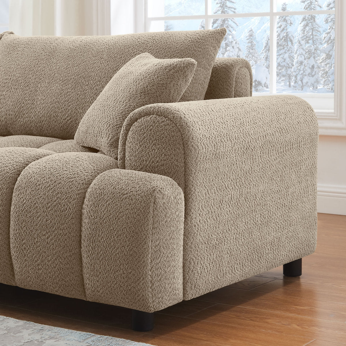 Beige sofa with textured fabric in a room with large windows showing snow outside.