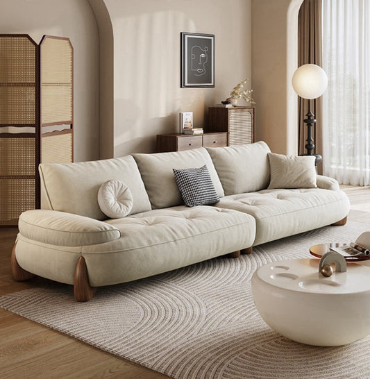 Beige sofa in a living room with a coffee table and decorative items.