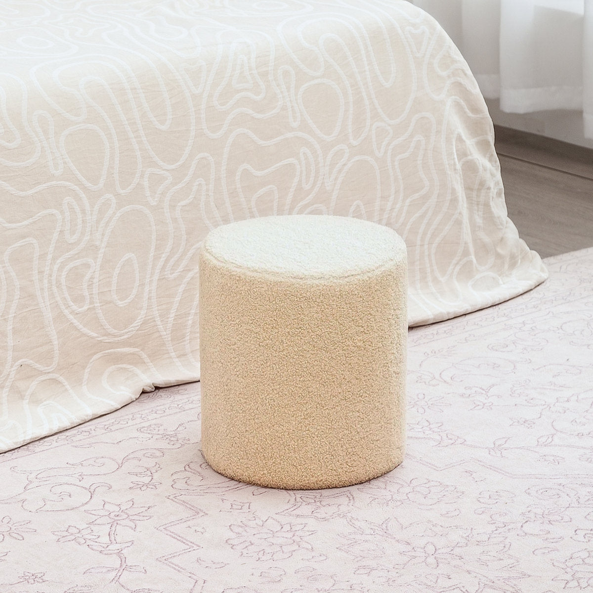 Beige textured ottoman on a bed with white bedding