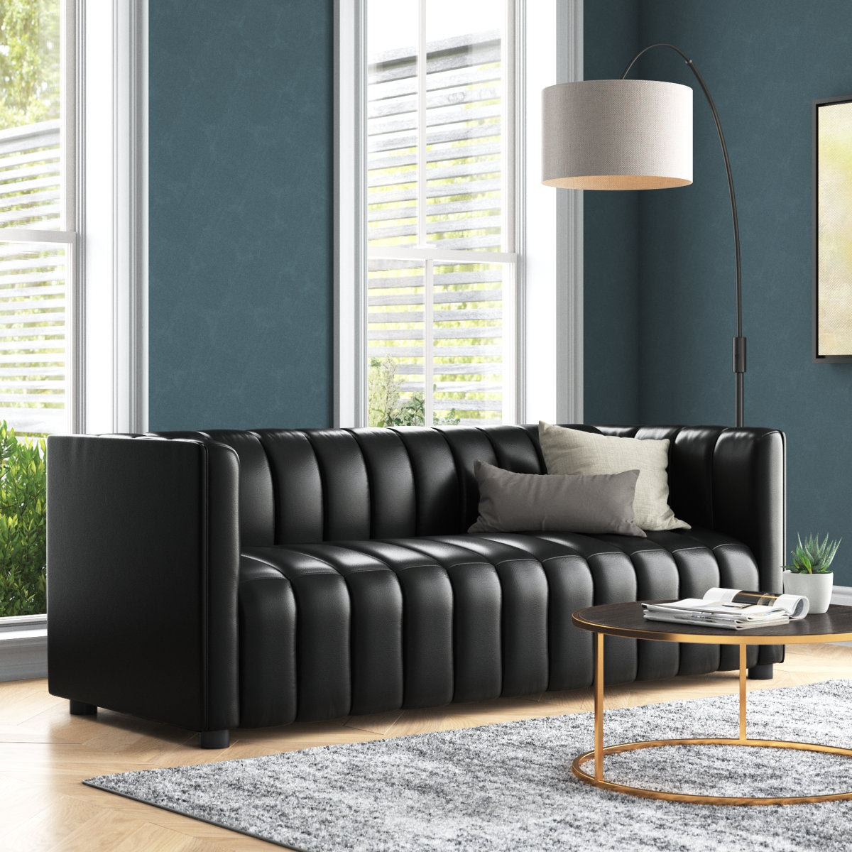 Black leather sofa in a modern living room with a lamp and coffee table.