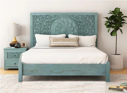 Blue wooden bed with intricate carvings in a bedroom setting