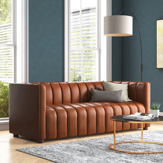 Brown leather sofa in a living room with a lamp and coffee table.