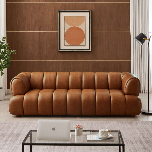 Brown leather sofa in a living room with a coffee table and decorative items.