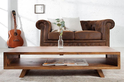 Brown leather sofa with a wooden coffee table in a living room setting.