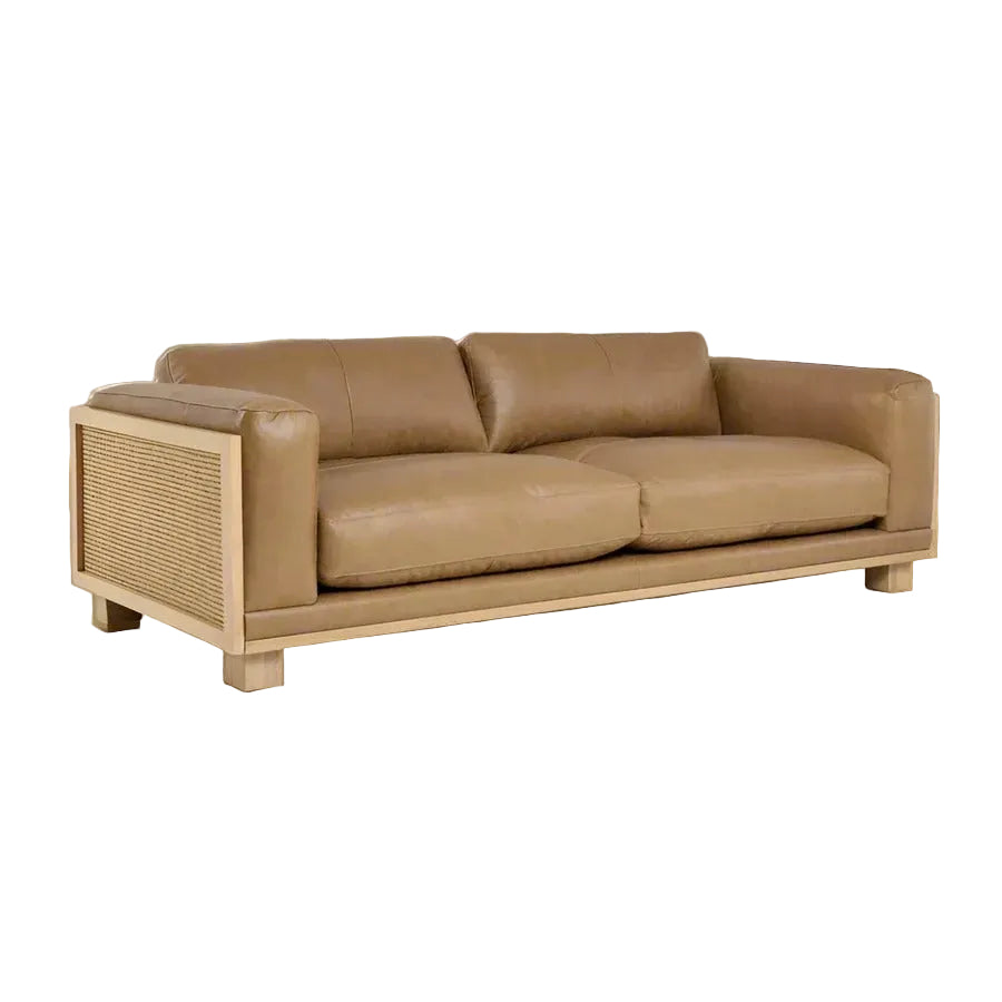 Brown leather sofa with wicker armrests on a white background