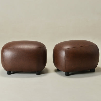 Two brown leather ottomans on a beige background