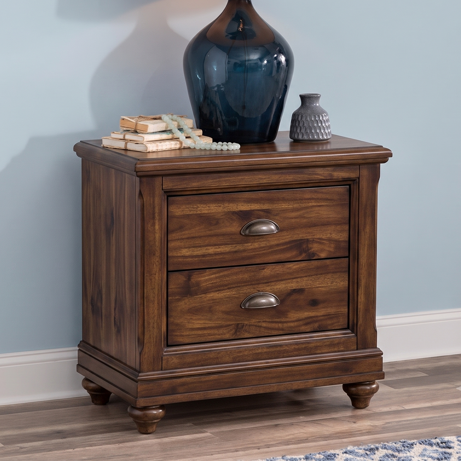 Wooden nightstand with two drawers against a light blue wall.