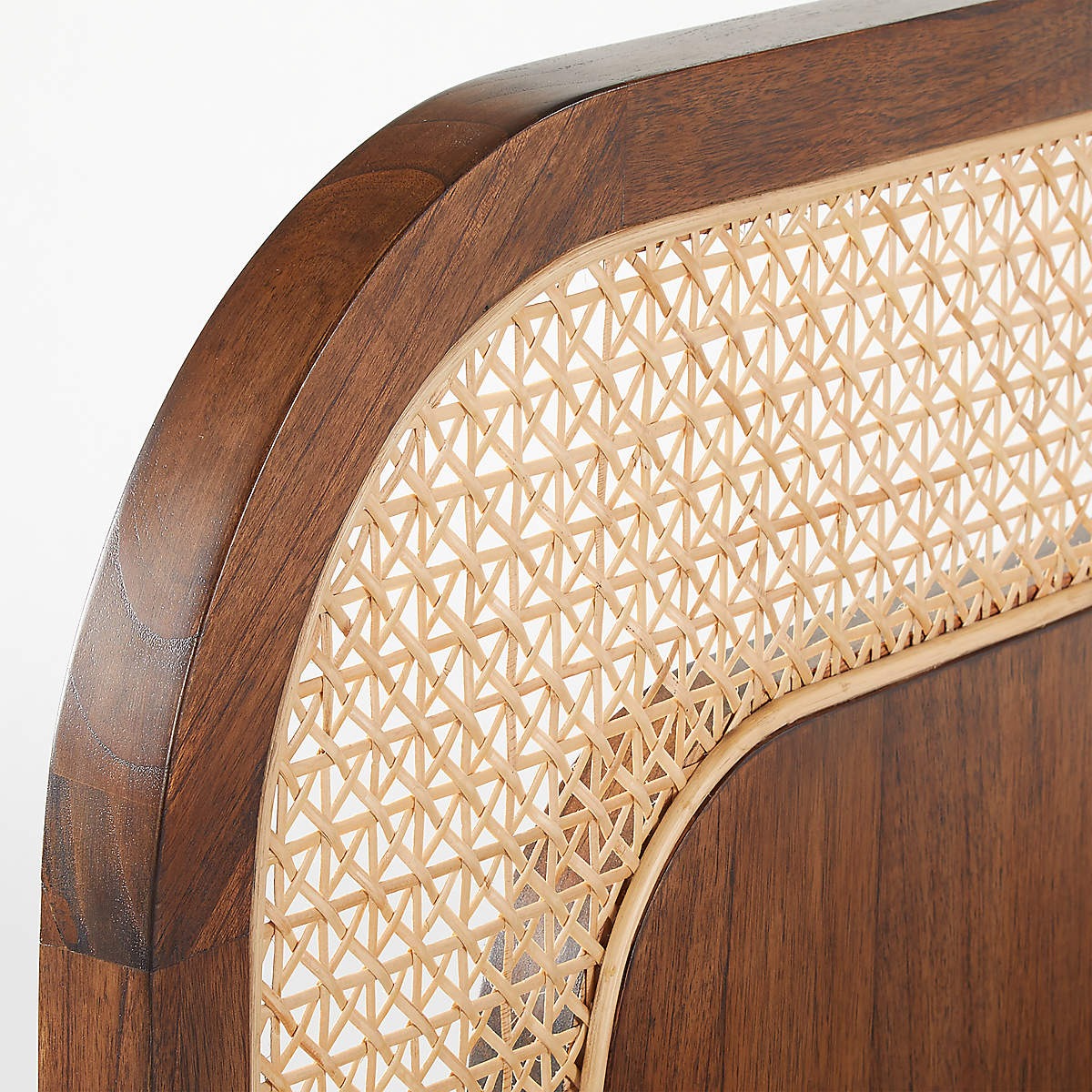Close-up of a wooden headboard with woven wicker design