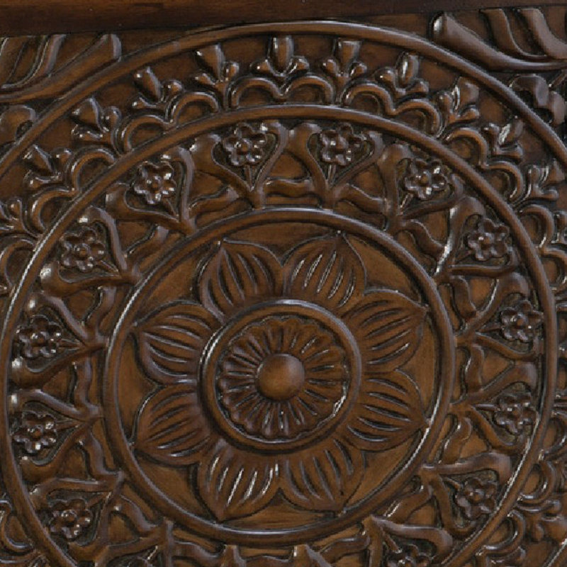 Close-up of a wooden surface with intricate carvings and floral patterns.