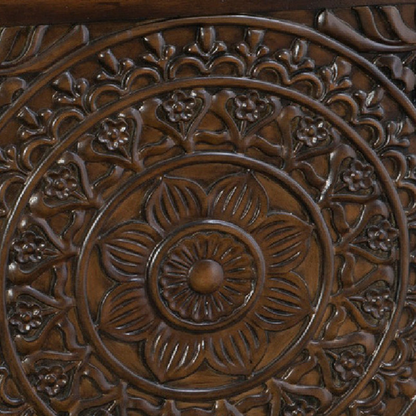 Close-up of a wooden surface with intricate carvings and floral patterns.