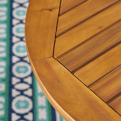 Close-up of a wooden table with a colorful patterned fabric in the background