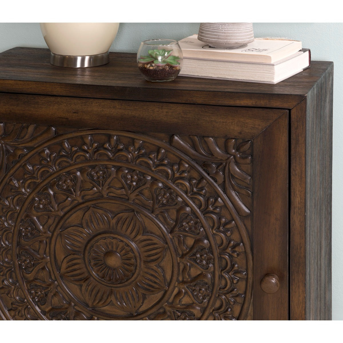 Wooden sideboard with intricate carvings on a light blue background