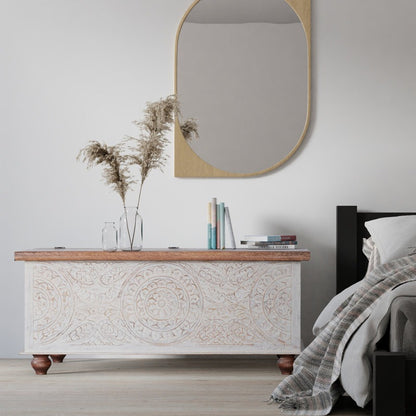 Decorative chest with wooden top and intricate carvings in a bedroom setting.