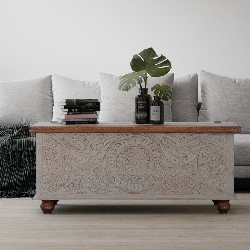 Decorative coffee table with intricate carvings in a living room setting.