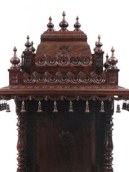 Decorative wooden structure with intricate carvings and hanging elements on a white background