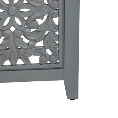 Decorative wooden table with intricate leaf patterns on a white background.