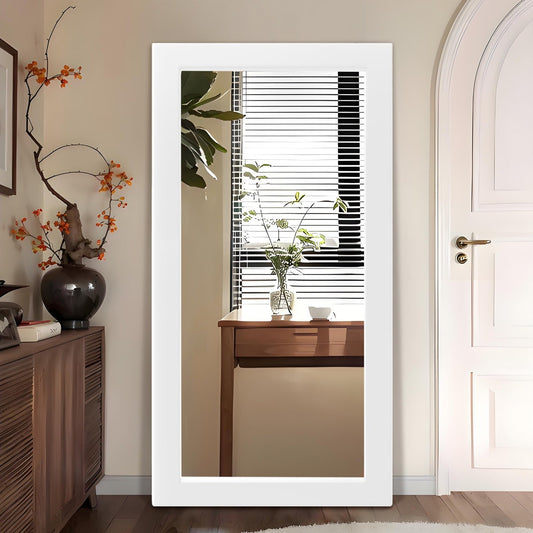 Full-length mirror leaning against a wall with a wooden cabinet and decorative items.