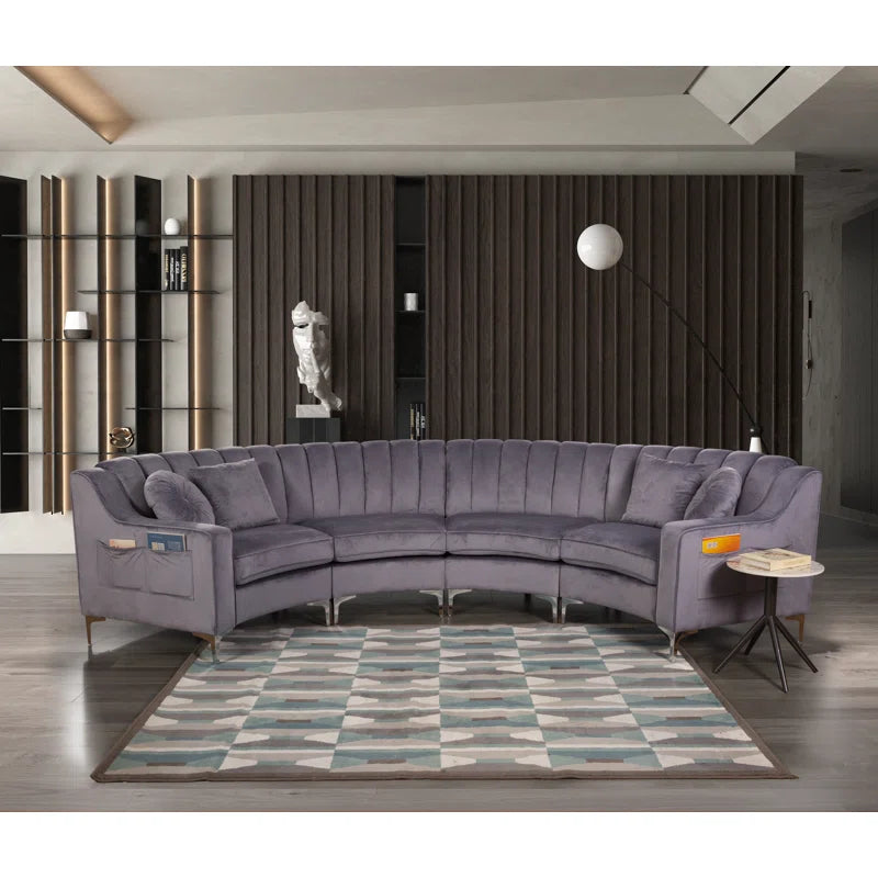 Gray sectional sofa in a modern living room with a geometric rug and decorative wall.